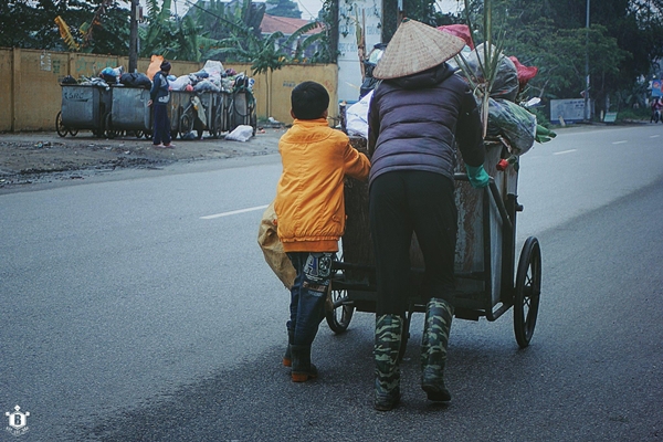 buc-anh-xuc-dong-cau-be-hi-hui-giup-me-dy-xe-rac-giua-ngay-dong