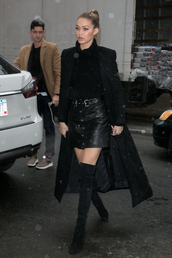 Gigi Hadid wearing a skirt from The Kooples, a Blaq sweater, and Stuart Weitzman over-the-knee boots.  