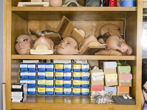 Read Doll faces, both male and female, sit on shelves.