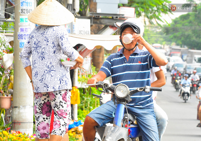 Người dân phun nước, trùm như ninja để đối phó với nắng nóng gần 39 độ C ở Sài Gòn - Ảnh 7.