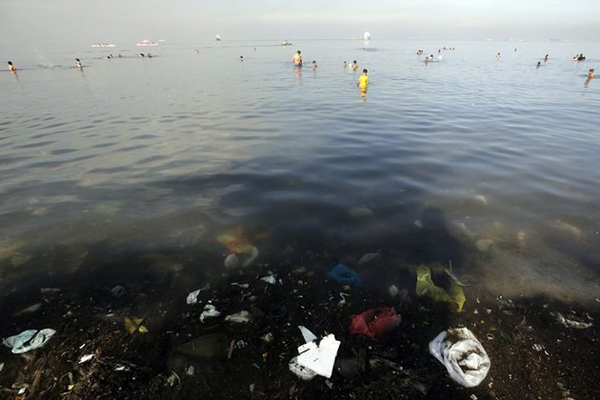 Nhiều người dân ra tắm ở vùng nước ô nhiễm trên vịnh Manila, dù họ đã được Bộ Môi trường và Tài nguyên Thiên nhiên Philippines cảnh báo rằng khu vực này không đủ điều kiện vệ sinh để tắm hay bơi lội. Ảnh: Ritchie B Tongo/EPA.