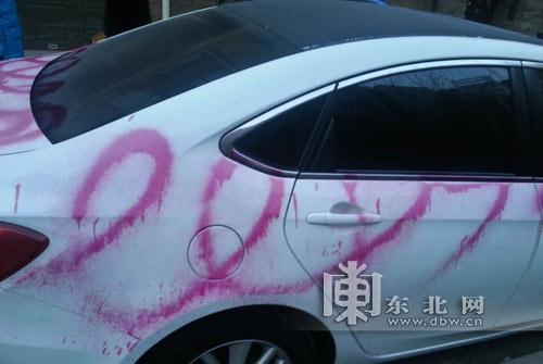 Chiếc ô tô trắng bị phun sơn hồng lem nhem.
