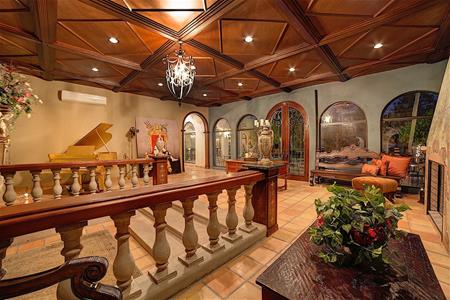 Phòng giải trí có trần gỗ xa xỉ, kết hợp cùng nội thất đắt tiền và một cây đàn piano lớn