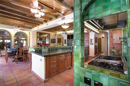 Phòng bếp với bờ tường ốp gạch hoa xanh, thể hiện phong cách kiến trúc Địa Trung Hải đậm đặc