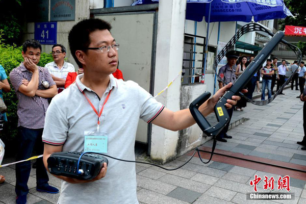Kỷ luật trường thi năm nay được truyền thông Trung Quốc đánh giá là "nghiêm   ngặt nhất trong lịch sử". Trong hình, nhân viên kỹ thuật đang dùng thiết bị dò   sóng vô tuyến.