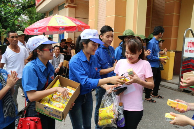 Tặng sữa, bánh mỳ cho thí sinh sau giờ thi - Ảnh: HOÀI NAM