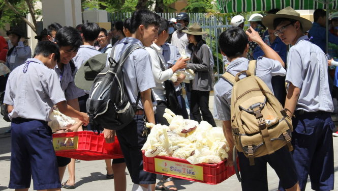 Bánh mì được phát miễn phí trước điểm thi trường THPT Trần Phú, Đà Nẵng nhưng không nhiều người nhận - Ảnh: TRƯỜNG TRUNG