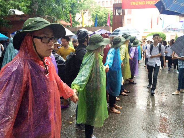  Cảnh SVTN trường Đại học Thủy lợi mặc áo mưa phân luồng giao thông sau giờ thi. 