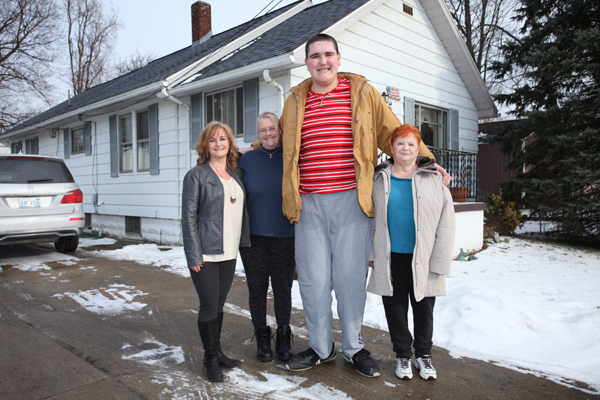 Broc poses with his family outside their home in Jackson, Michigan