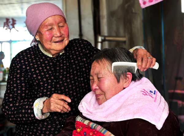 Cụ Sun Yincong tình cảm chải tóc cho con dâu. Ảnh: China Daily]