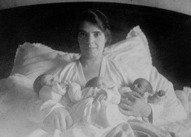  Bà mẹ Mabel Bloxham trên giường ngủ với 3 đứa con sinh ba những năm 1930. 
