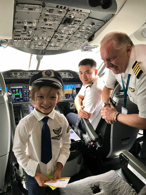 Bé Tôm, con gái ca sĩ Hồng Nhung thích thú khi được mặc quần áo phi công đứng trong khoang lái máy bay trước giờ khởi hành.