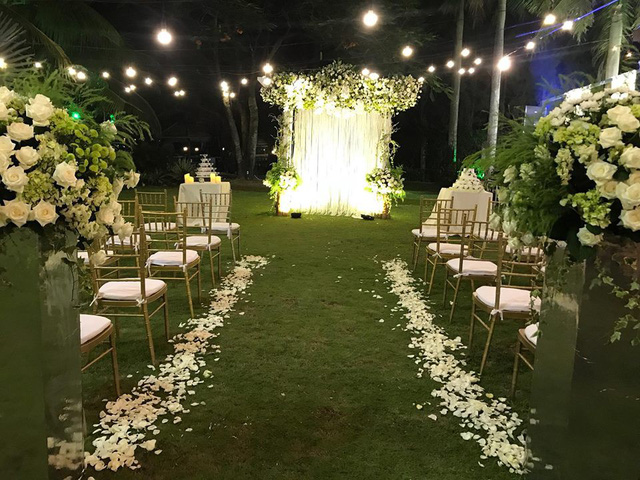 Không gian tiệc cưới được trang trí nhiều hoa hồng, hoa lan với tông màu trắng chủ đạo