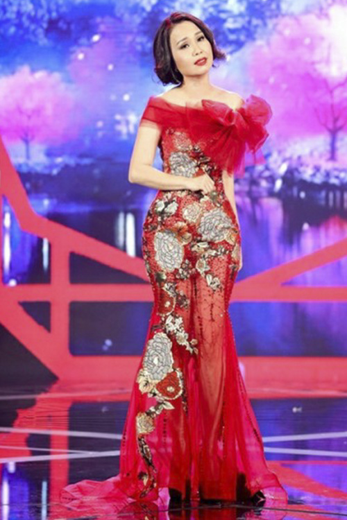 “Chị Tư” Cẩm Ly diện đầm đỏ với họa tiết hoa bản to, bẹt vai, thắt nơ sến sẩm và cực kì rối mắt. Mái tóc “bến Thượng Hải” cũng như đôi giày đen “chỏi mắt” cũng là những điểm trừ cho nữ ca sĩ.