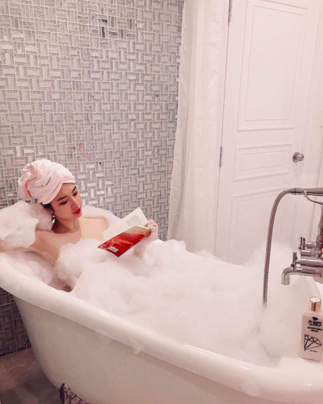 Angela Phương Trinh “sống ảo”, đọc sách trong khi đang ngâm mình trong bồn tắm.