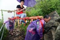 Nam sinh Trung Quốc bị  ném đá  vì thuê người già kiệu lên núi